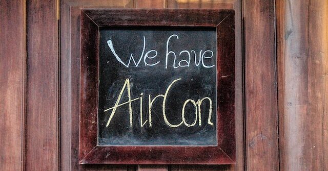 a chalk board saying "we have aircon"